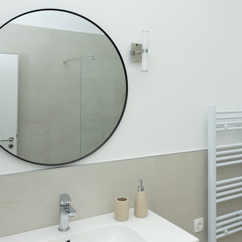 Modern en-suite bathroom with round mirror