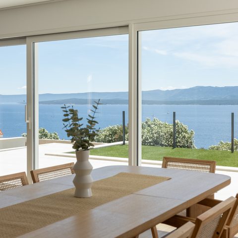 Dining room with garden and sea view through wide windows
